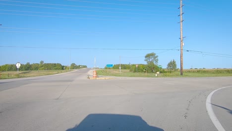 pov driving on a rural paved road, turning a corner at a stop sign