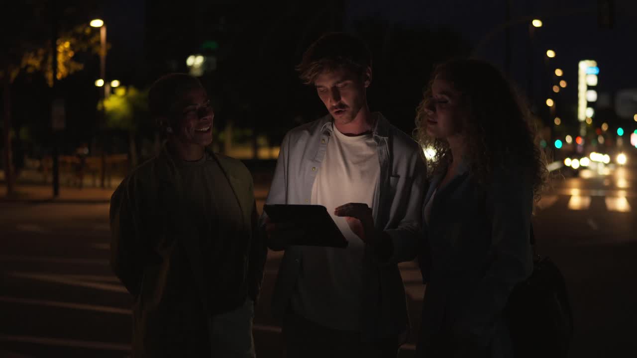 People using a tablet at night in the city