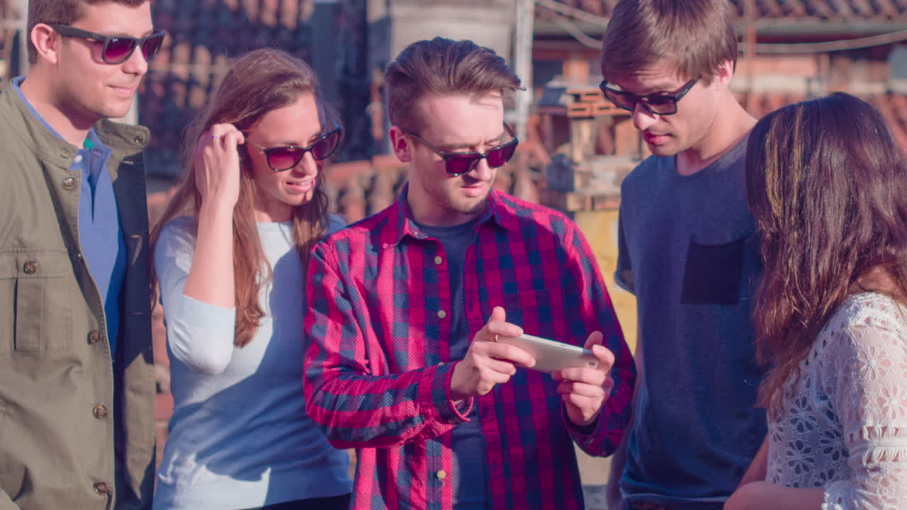 친구 들 이 지붕 에 있는 스마트폰 을 보고 있다