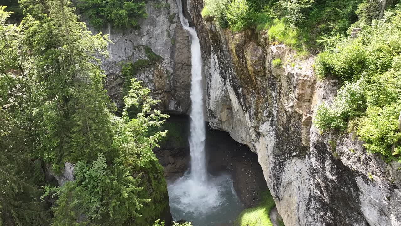 una cascada que desciende por acantilados rocosos rodeados de un bosque exuberante en glarus süd, suiza