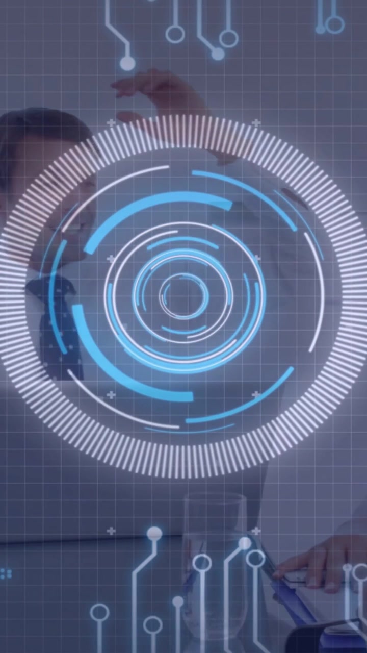 Pen entering frame initiating notepad writing while team using tablet beneath HUD in office meeting