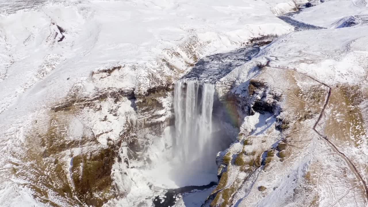 un dron 4k captura imágenes aéreas distintivas de cascadas enmarcadas por un sereno paisaje cubierto de nieve, ofreciendo una experiencia cinematográfica como ninguna otra.