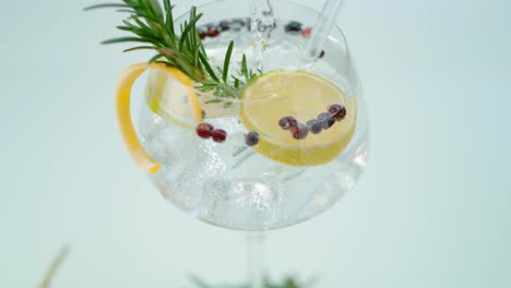 Crystal-Water-Pouring-over-Ice-and-Lemon-Slices-in-Cocktail-Glass