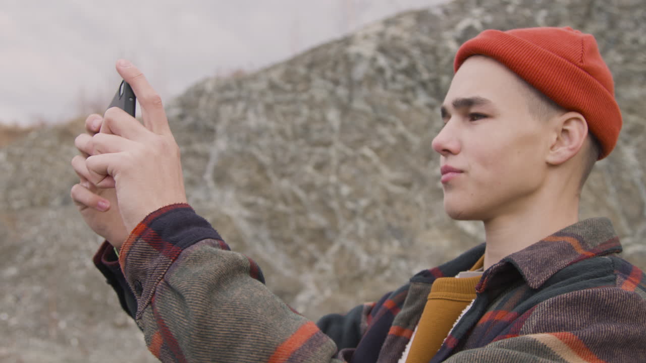 산에서 스마트폰을 사용하는 10대 소년의 시야를 닫습니다