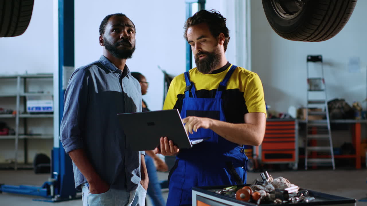 mecánico y hombre en busca de piezas de automóvil