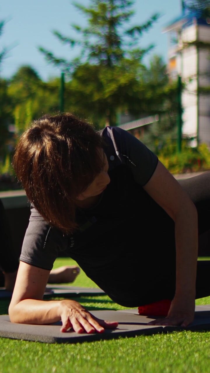 Woman Performing Myofascial Release Exercise with Massage Ball Outdoors