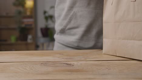 close up of man at home taking romantic valentines gifts out of bag