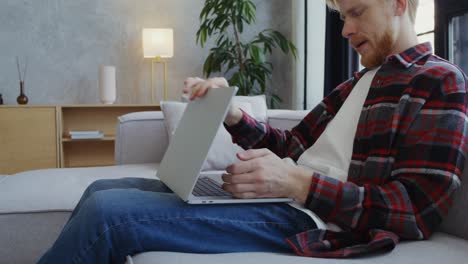 hombre trabajando en una computadora portátil en casa