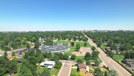 Aerial-Flyover-of-Suburban-Neighborhood-near-Denver-Colorado-with-houses,-school-and-road