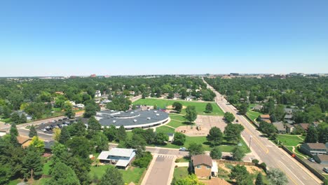 sobrevuelo aéreo de un vecindario suburbano cerca de denver colorado con casas, escuela y carretera