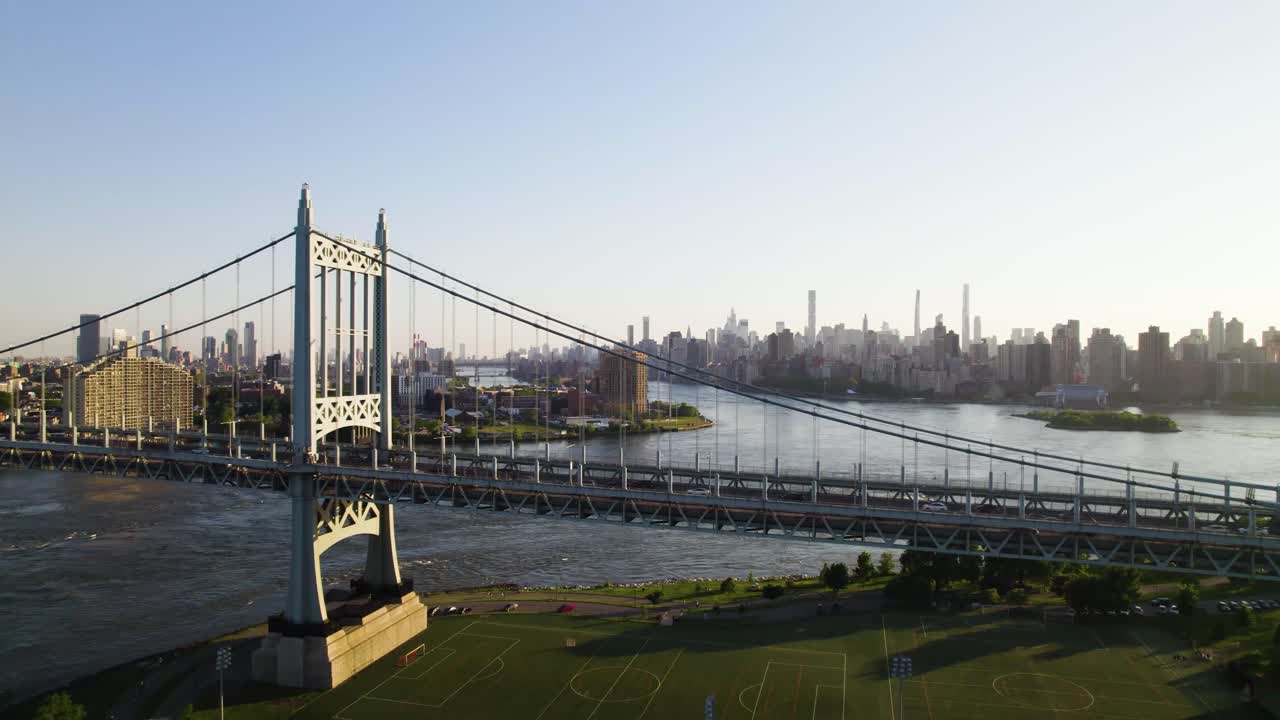 NYC suspension bridge, skyline, with sports fields and park space in foreground