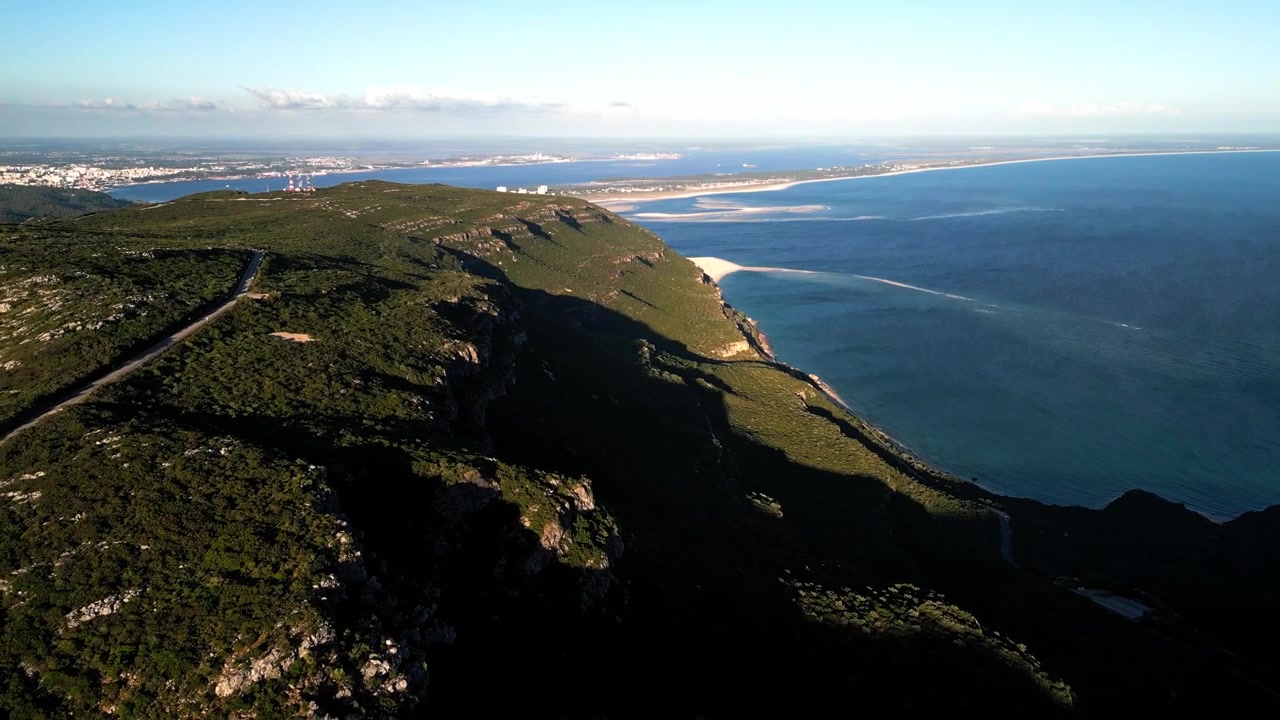Veduta aerea di scogliere lussureggianti e costa che si ergono sopra il mare blu in una giornata limpida