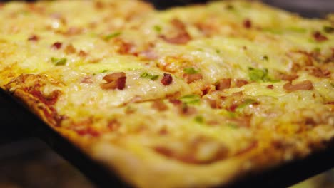 primer plano de cursi, pan cuadrado, combinación de pizza con jamón y pimientos verdes