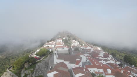 Eine-Drohne-Fliegt-über-Die-Orangefarbenen-Ziegeldächer-Eines-Portugiesischen-Dorfes-Und-In-Die-Überreste-Der-Burg-Marvão