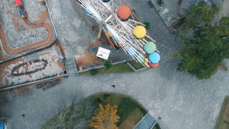 aerial drone shot of abandoned soviet amusement park with ferris wheel