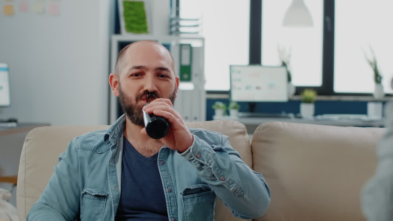 Portrait of man drinking beer from bottle and enjoying free time
