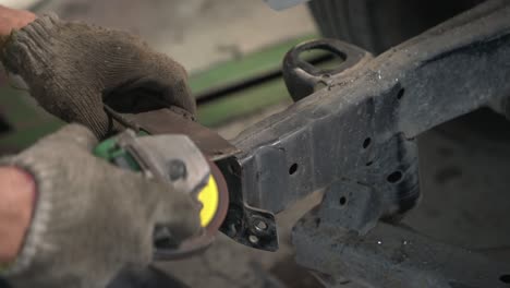 molienda de ruedas eléctricas en el chasis de un automóvil - taller de reparación de carrocerías de automóviles