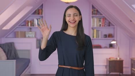 happy indian girl waving hi to the camera