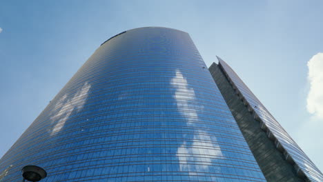 modern skyscraper in milan with reflective glass facade and blue sky