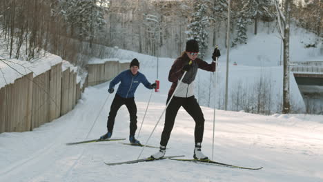 two cross-country skiers practicing on a snowy trail