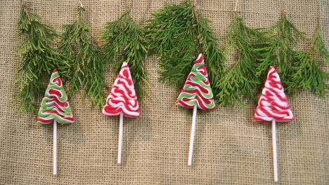 Christmas-tree-lollipops-with-fir-leaves-on-textile-4k