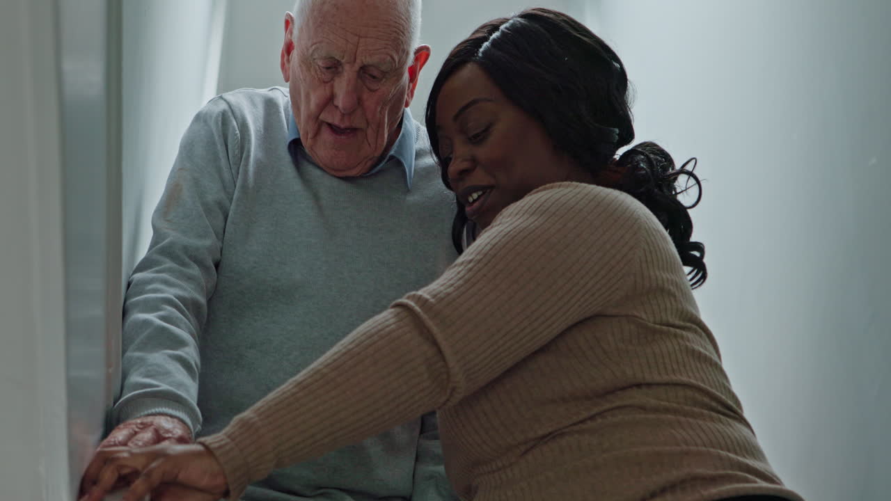 Caregiver assisting elderly man on stairs
