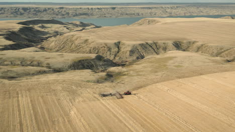 Siembra-En-Tierras-Agrícolas-En-Canadá-En-El-Lago-Diefenbaker,-Toma-Aérea-De-Drones