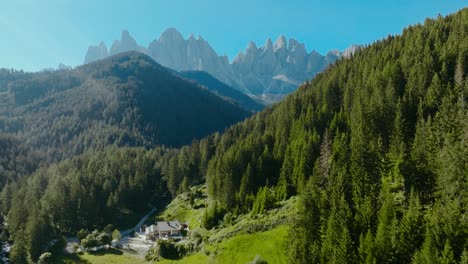 toma aérea de los dolomitas en la iglesia de san giovanni en ranui con el bosque y los alpes en la parte de atrás, italia, dolomitas