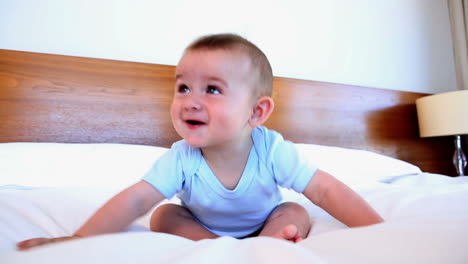 cute baby boy sitting on bed