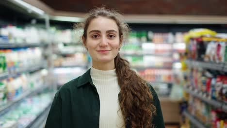 Portrait-of-the-young-beautiful-woman-smiling-happily-to-the-camera-at-the-grocery-supermarket