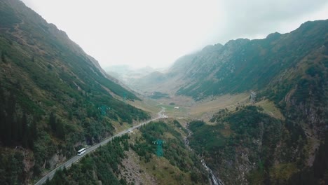 Forward-drone-shot-with-a-light-vertical-panning,-of-a-mountain-road-next-to-a-cliff