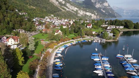 imágenes aéreas del lago con deportes acuáticos y muchos barcos en una ciudad ubicada en el valle entre las montañas