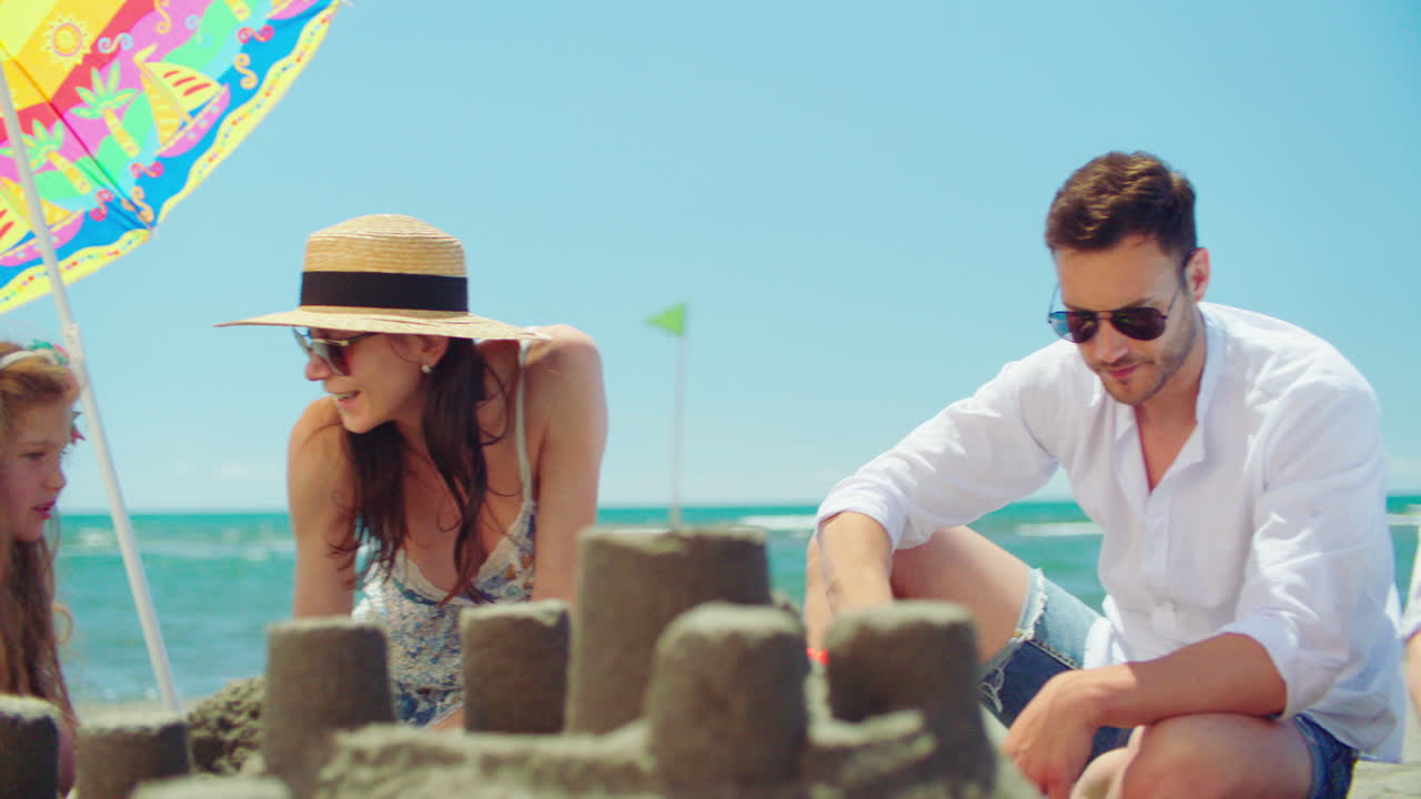 familia construyendo castillos de arena en la playa