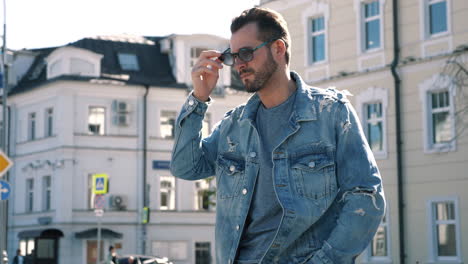 man in denim jacket walking on city street