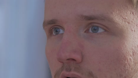 close-up of a young man with blue eyes focusing on the task he is presented with on the computer screen