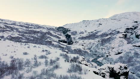 Gente-Haciendo-Senderismo-En-Una-Fría-Montaña-Nevada-En-Islandia-Durante-La-Temporada-De-Invierno---Drone-Aéreo