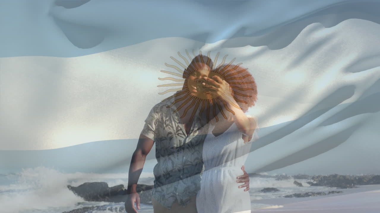 video compuesto de una pareja afroamericana agitando la bandera argentina tomando una selfie en la playa