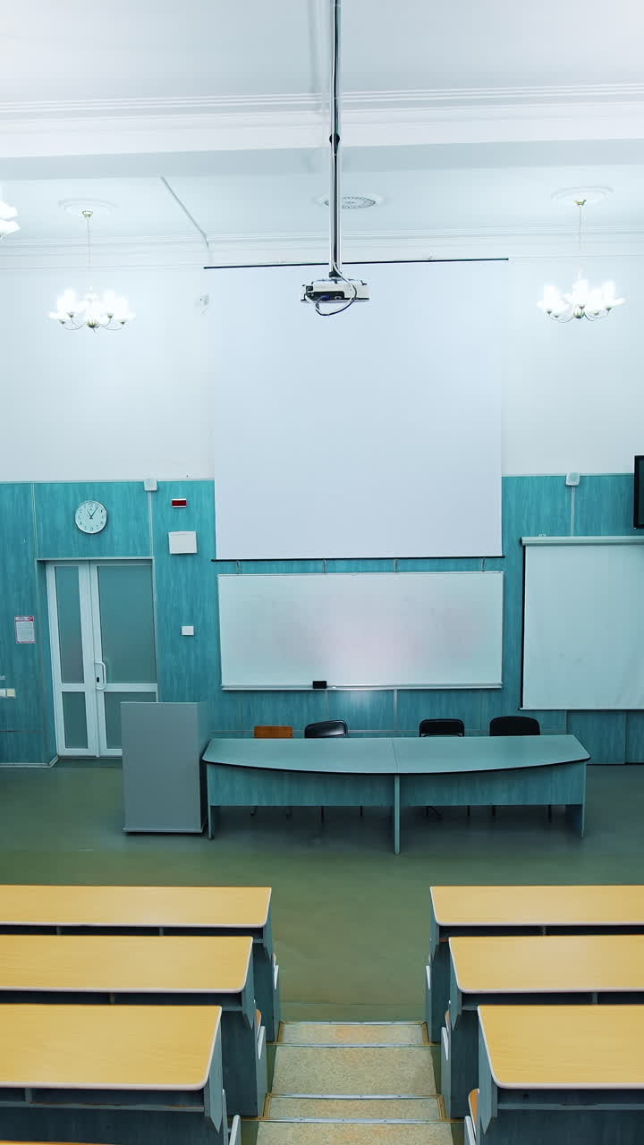 Empty lecture hall in the university. Beautiful classroom in the educational centre with modern interior. Conference hall with blackboard and modern equipment. Panoramic view. Vertical video