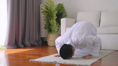 los musulmanes se inclinan para orar por bendiciones en la sala de estar, la creencia en el islam los musulmanes rezan en casa diariamente como una bendición para sí mismos y sus familias