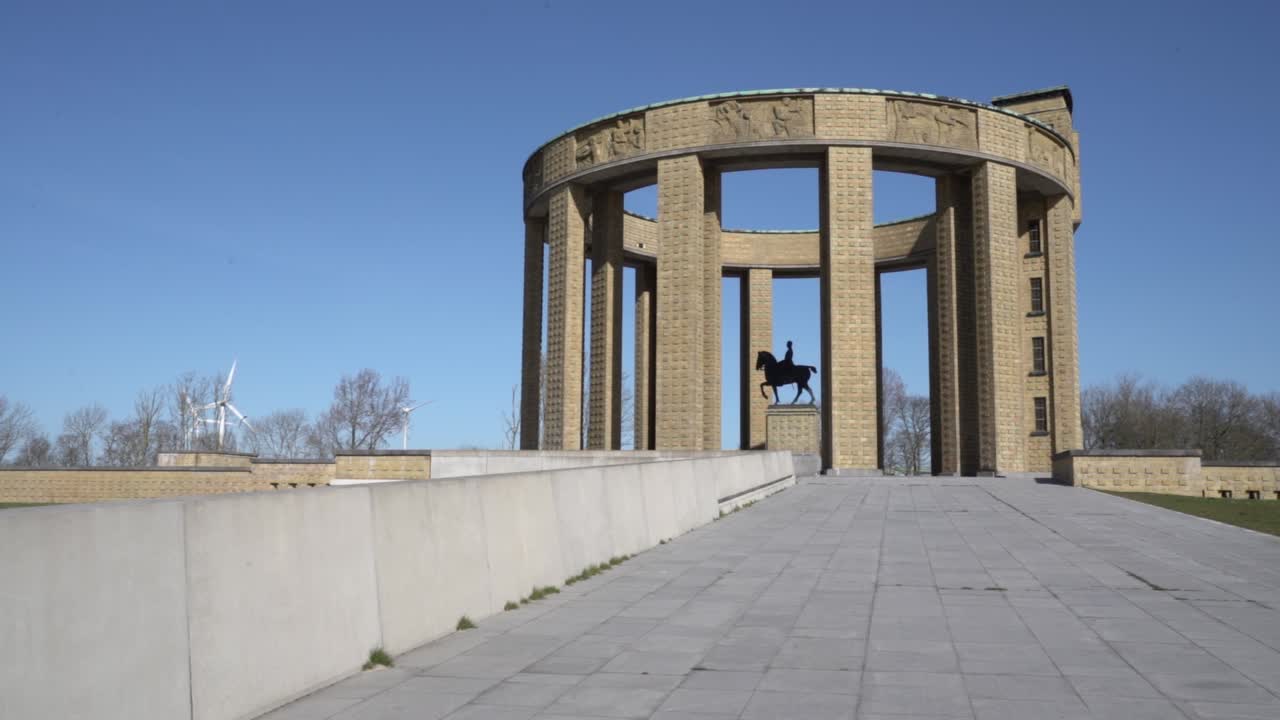 toma amplia que muestra el memorial del rey albert y el molino de viento en el fondo durante el cielo azul en nieuwpoort, bélgica