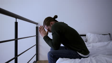 Worried-man-sitting-on-bed