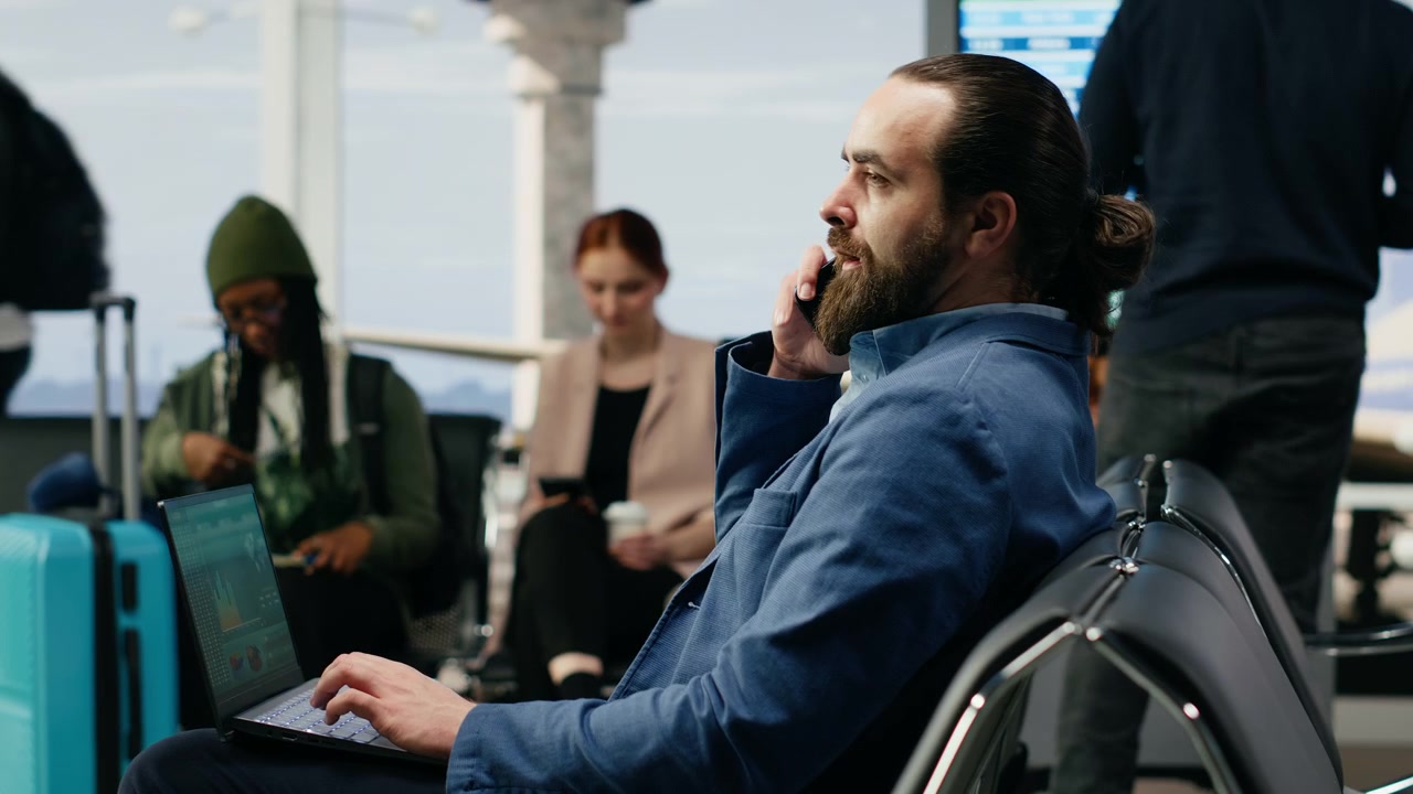 Biznesmen odbierający telefon w strefie odlotów na lotnisku.