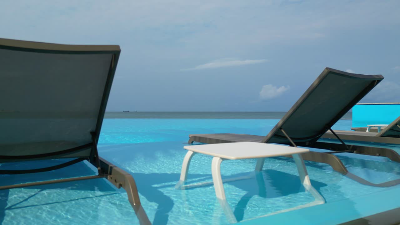 View of chairs and a table in an infinity pool.