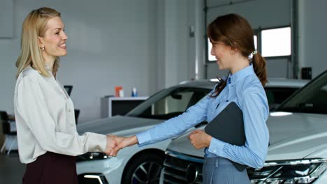 dos mujeres de negocios discutiendo la compra de un coche.