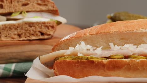 herring sandwich on a roll with pickles and onions