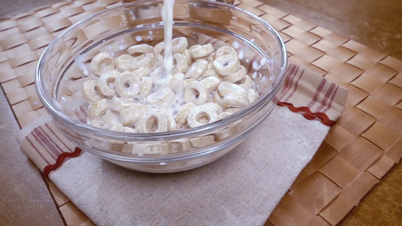 Knusprige Haferflocken in einer Schale für ein köstliches Frühstück mit Milch am Morgen. Zeitlupe mit rotierender Kamerafahrt