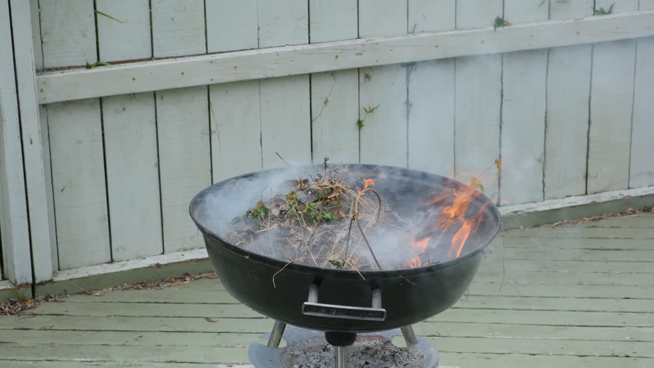 가까이에서, 뒷마당에서 건조한 잎을 태우는 연기가 발생합니다.