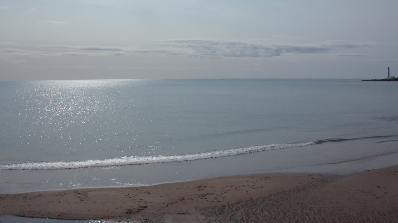 Extra wide panning shot of Montrose Beach with scurdie ness lighthouse