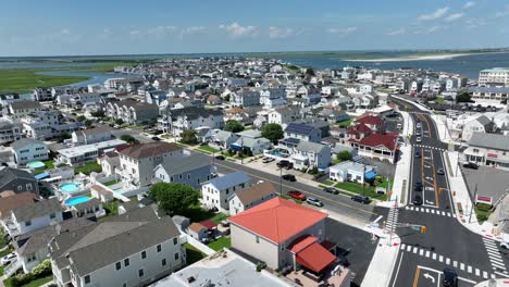 Aerial flyover American city of wildwood, New Jersey during sunny day with blue sky. Beach houses with wetland and marsh in background