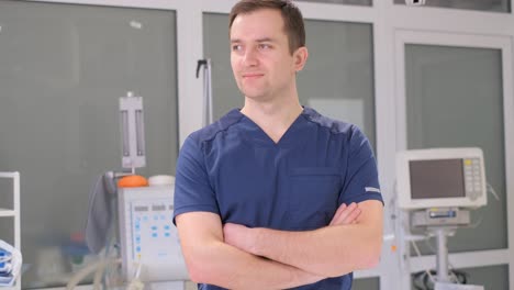 portrait of young chinese doctor in white medical gown and surgical mask looking into camera inside hallway hospital. medical staff. coronavirus quarantine. public safety. healthcare.